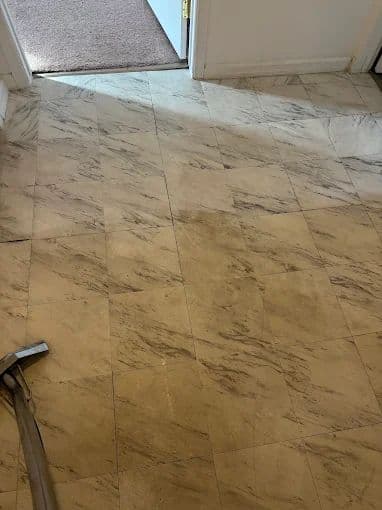 Hard floor being machine-cleaned to an even, polished finish